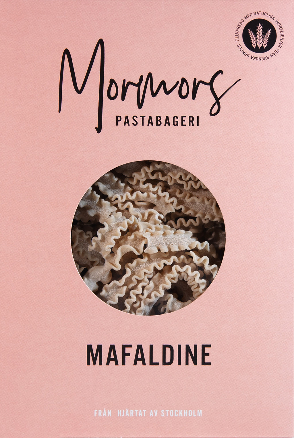 Rosa förpackning från Mormors Pastabageri med texten Mafaldine och ett runt fönster där de vågiga pastabanden syns.