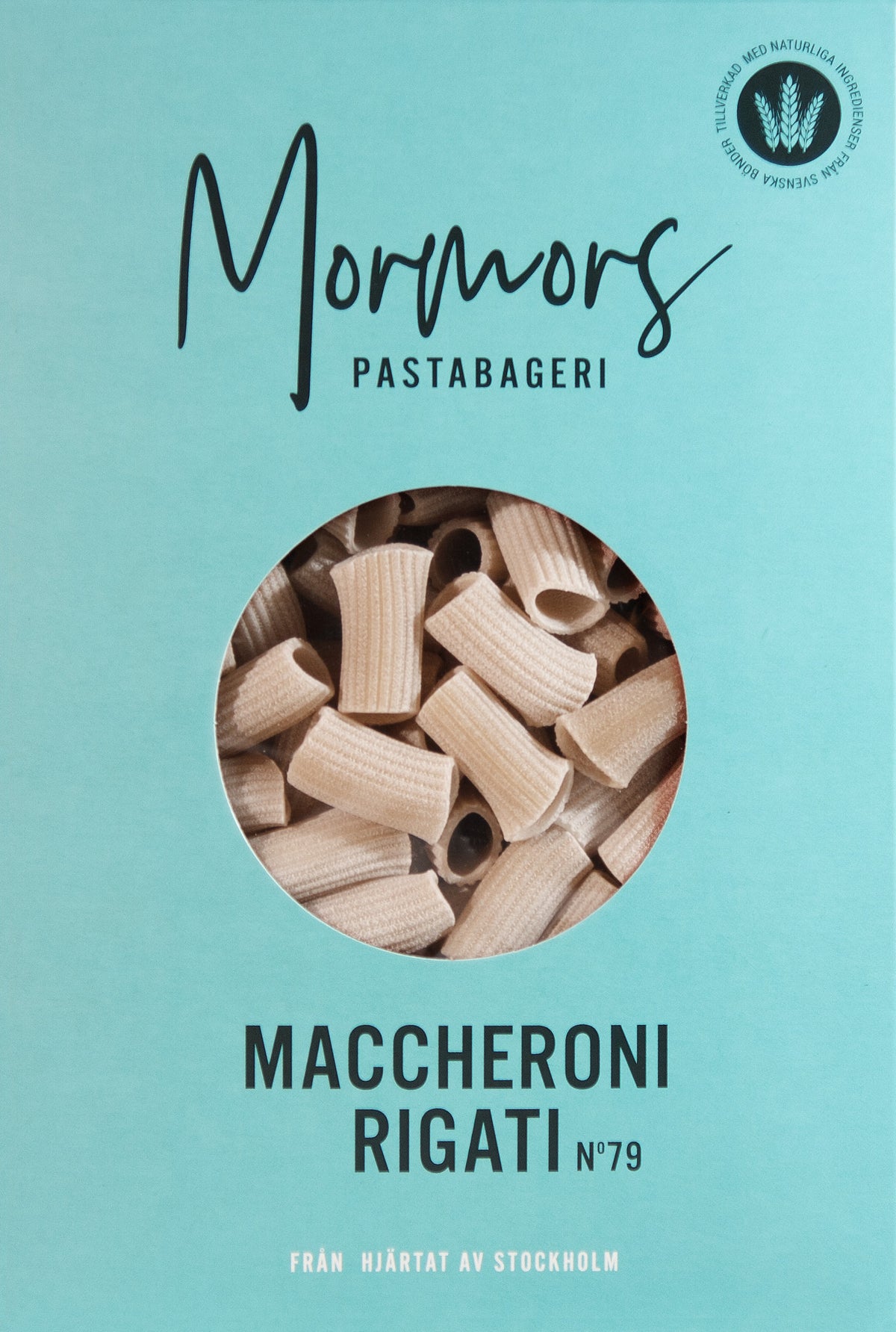 Turkos förpackning från Mormors Pastabageri med texten Maccheroni Rigati N°79 och ett runt fönster där de räfflade pastarören syns.