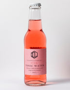Flaska Pink Tonic Water 20 cl från Infused Liquid med rosa etikett, mot ljus bakgrund.